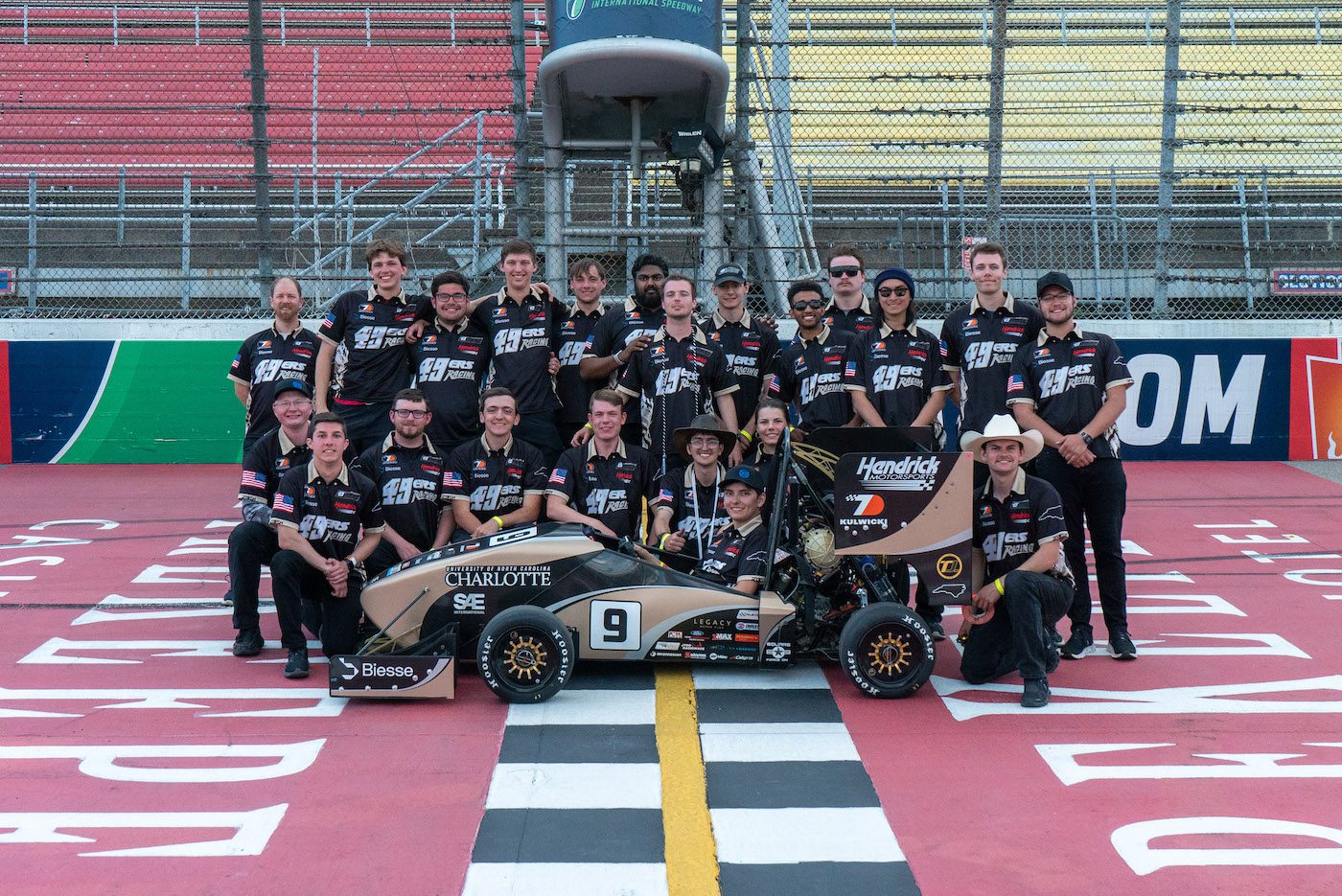 49ers Racing team members stand behind race car