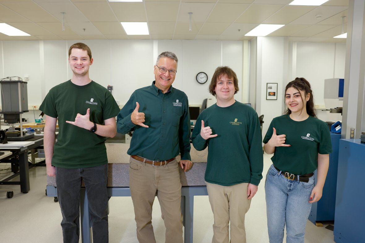3 students and professor posing for the camera