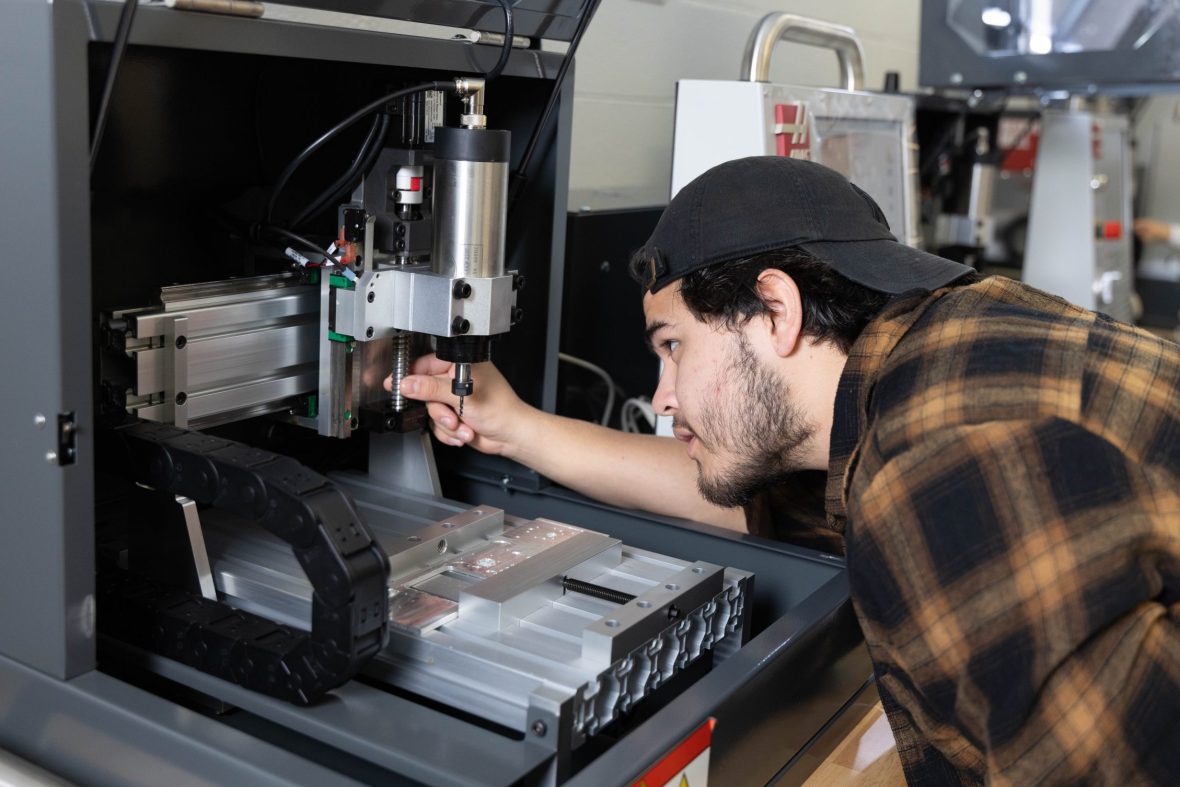 Student working with machinery in a lab