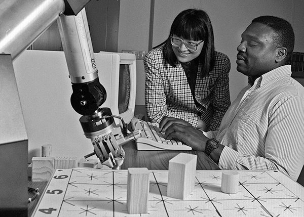 faculty member working with a student in a computer design lab