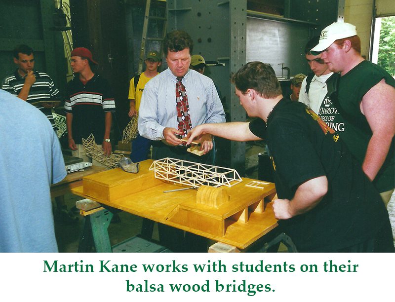 Martin Kane works with students on their balsa wood bridges