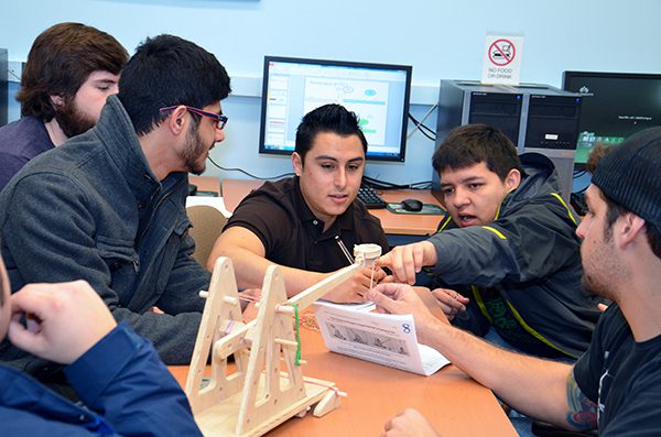 Engineering students building a model catapult