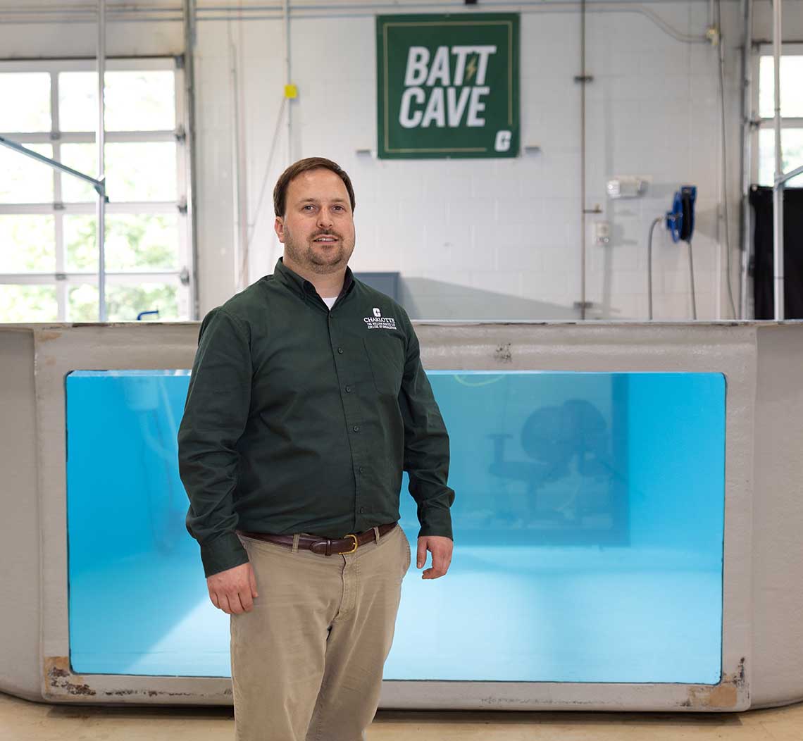 Artur Wolek stands in front of a water tank in the BATT CAVE research center