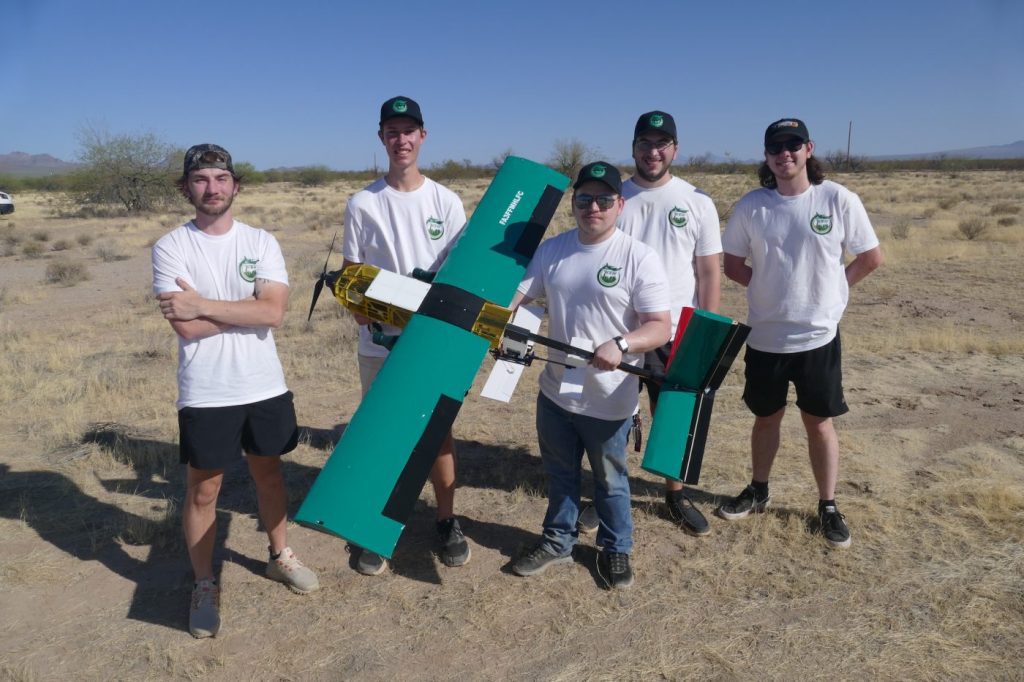 Students hold model airplane