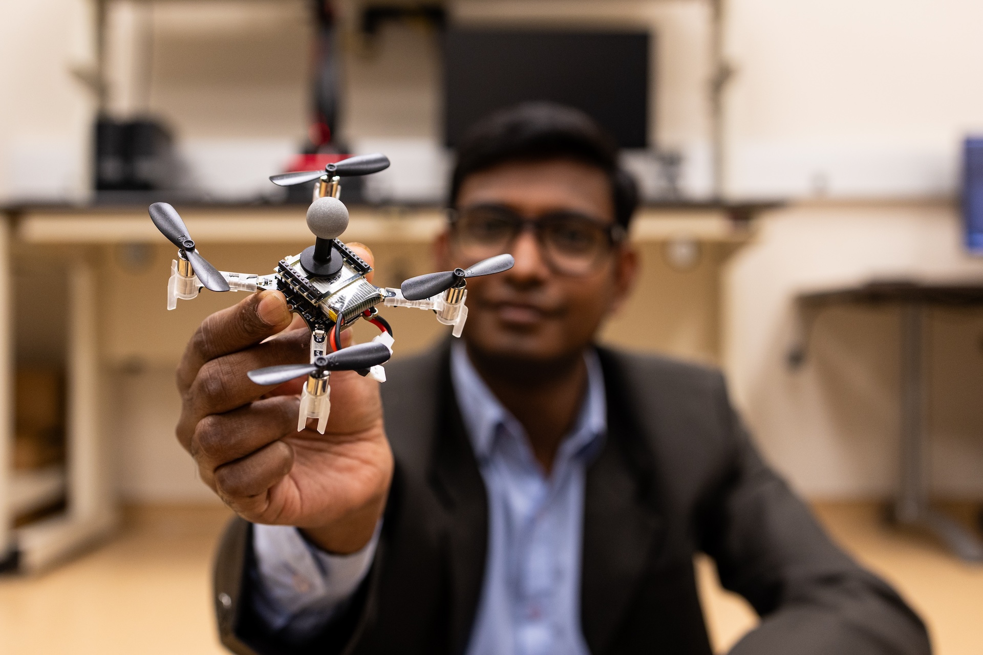 Dipankar Maity is the background with focus on foreground of his hand holding a drone