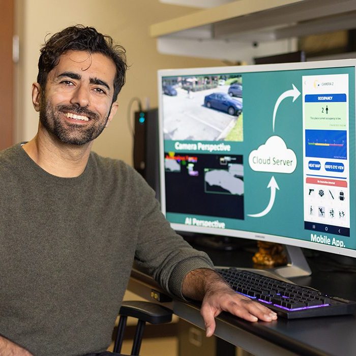 Portrait of Dr. Hamed Tabkhi at a computer.