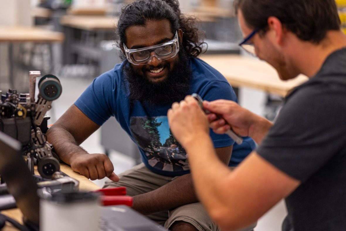 two students working with engineering equipment