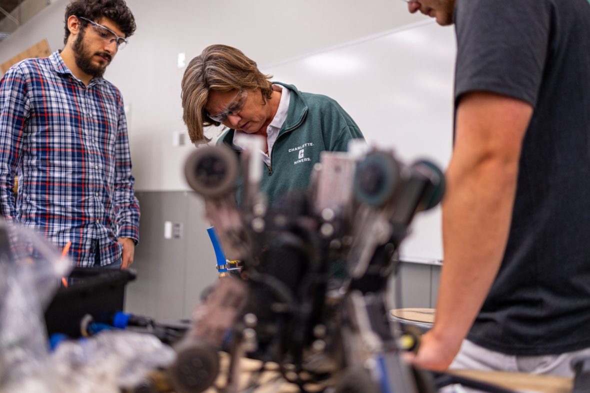 Mentor teaching students how to work with equipment