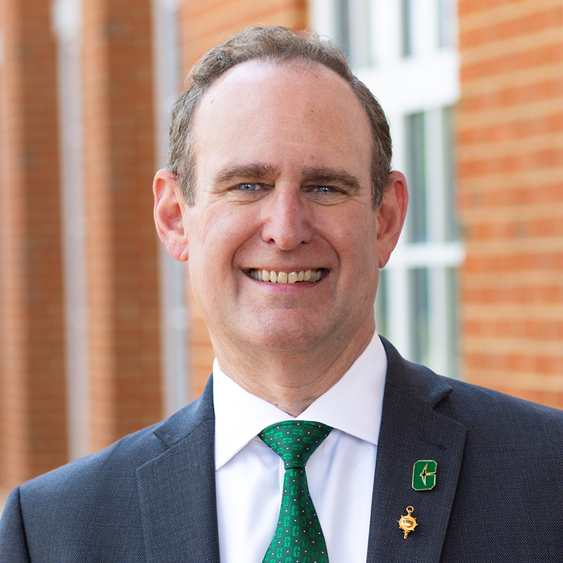 Portrait of Rob Keynton standing outside near a brick building