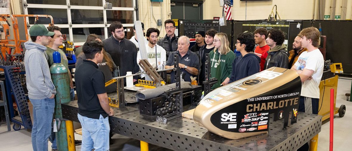 Professor talking to a group of students in the motorsports lab