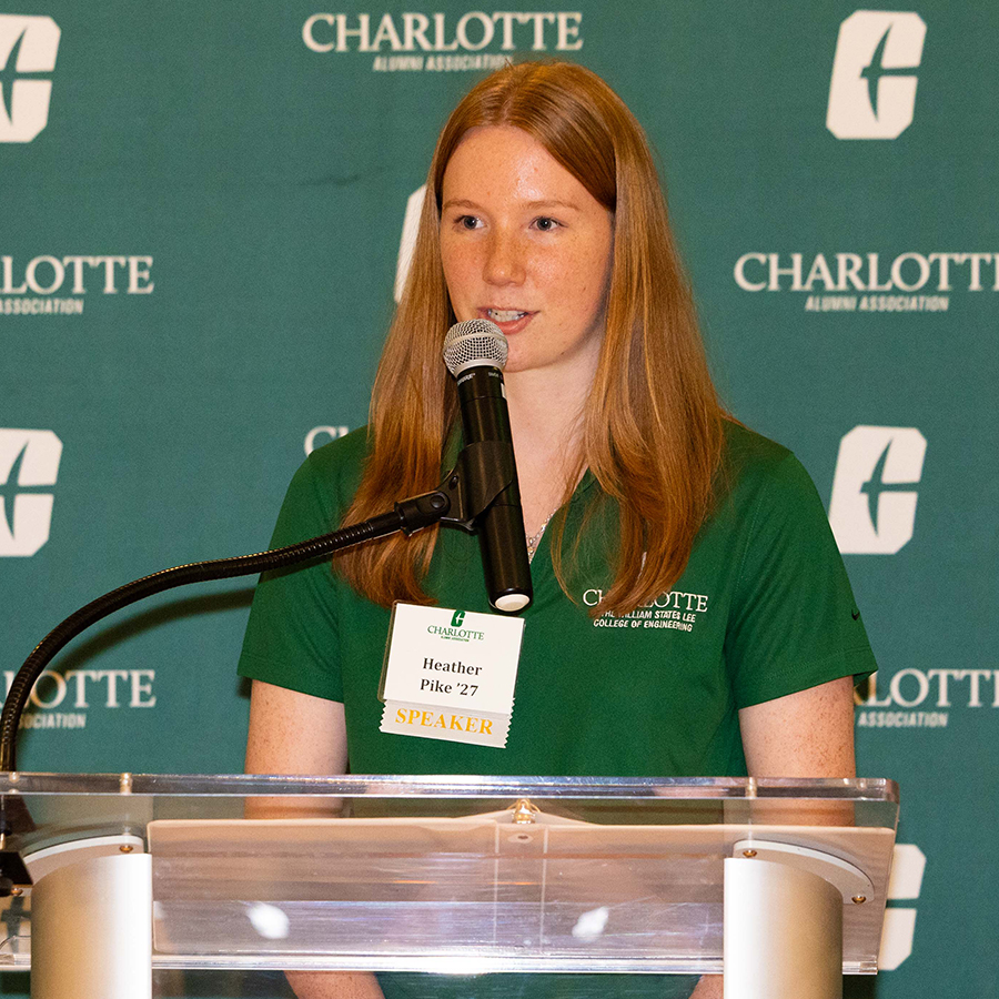 Heather Pike speaks at a podium during an event hosted by the University of North Carolina Charlotte Alumni Association.