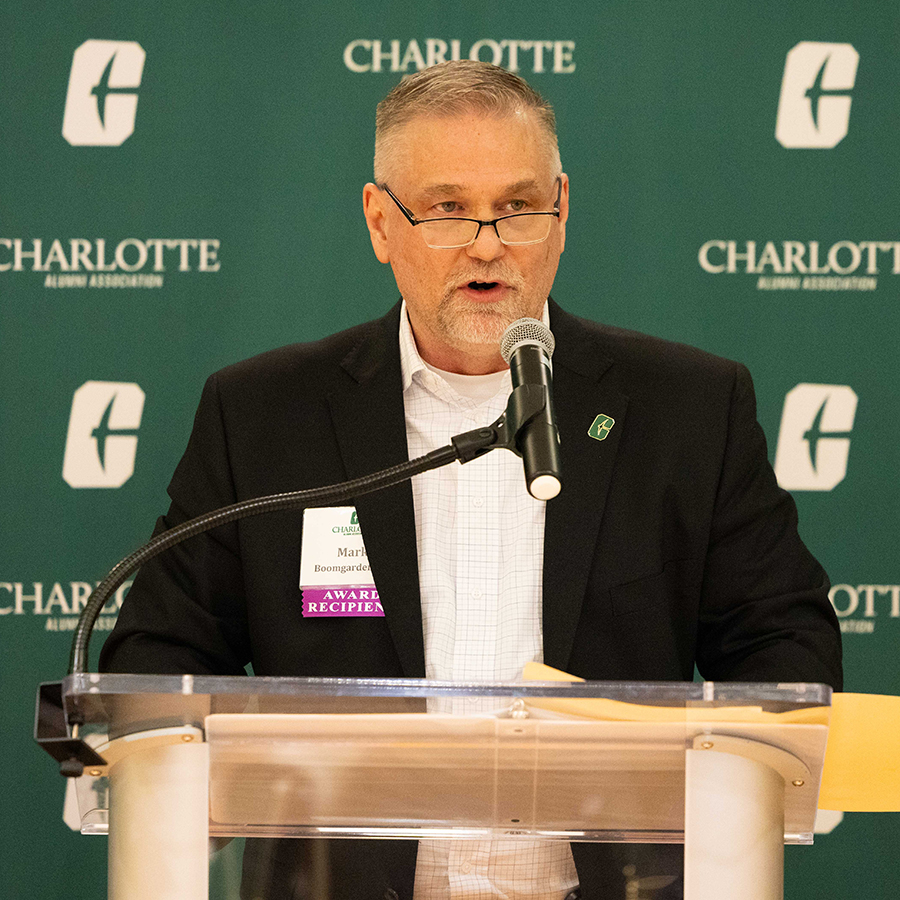 Mark Boomgarden speaks at a podium during an event hosted by the Charlotte Alumni Association.