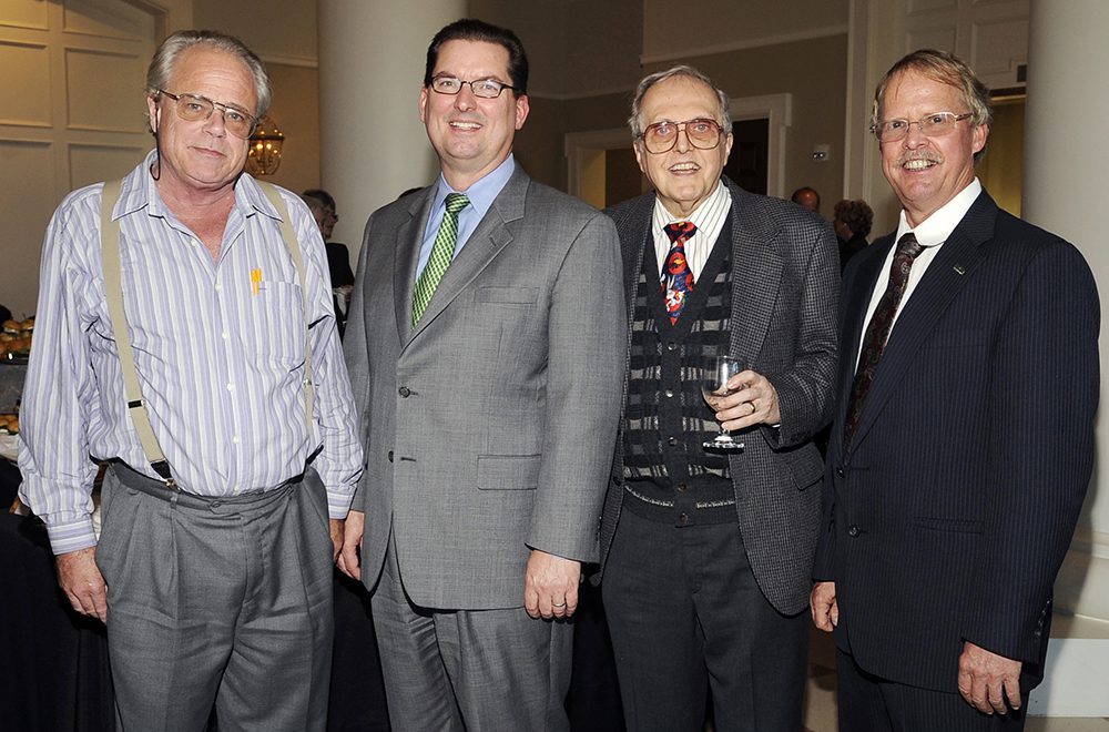 Four men stand for a group photo